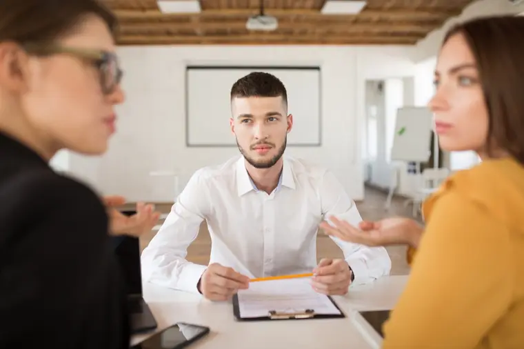 Tres personas conversan en una oficina