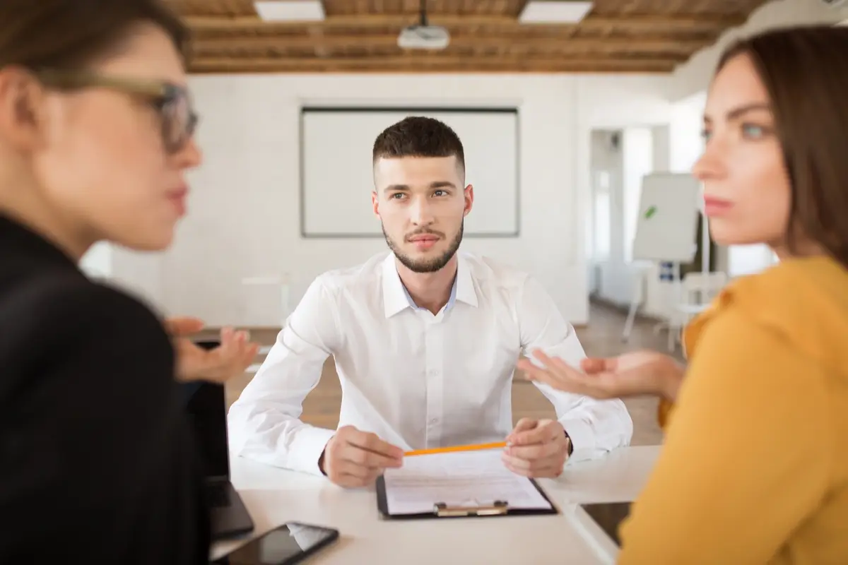 Tres personas conversan en una oficina