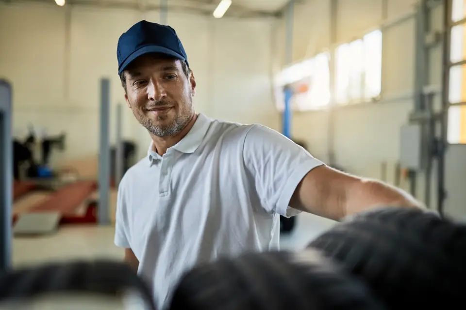 Supervisor de taller con gorra señala hacia su equipo